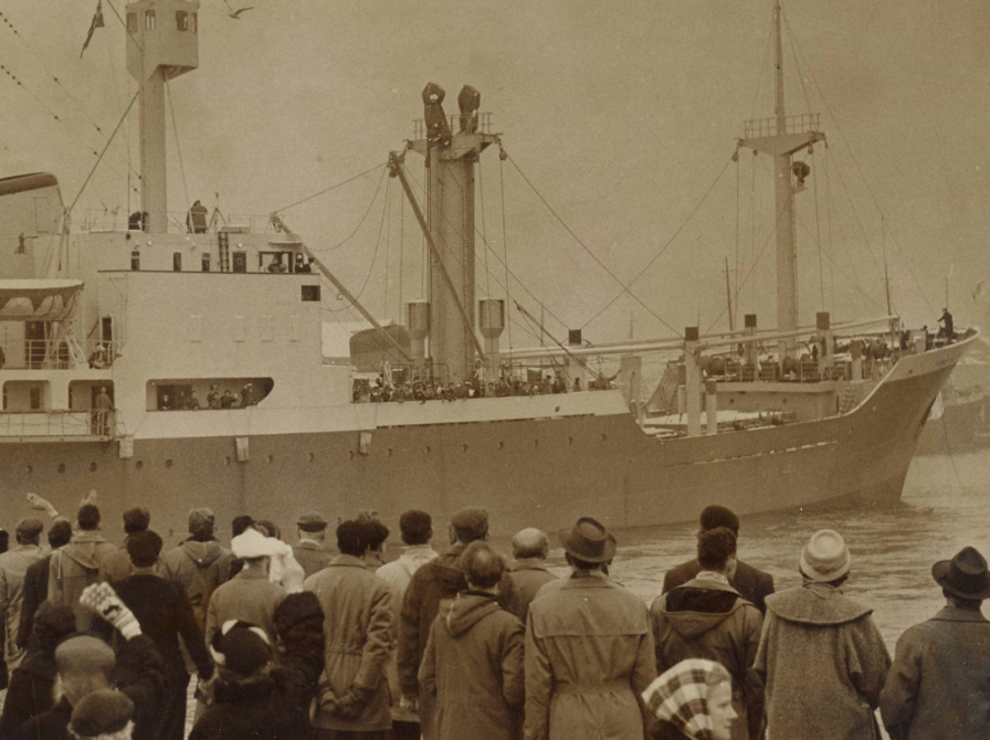 billede af skibet Hans Hedtoft der lægger fra kaj, mens familie kigger på