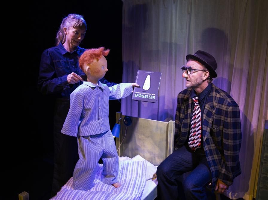 billede af dukke i seng der kigger på mand