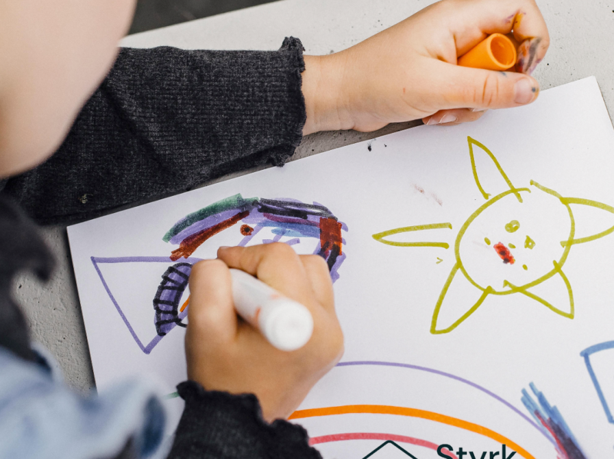 billede af barn der sidder og maler med en tusch